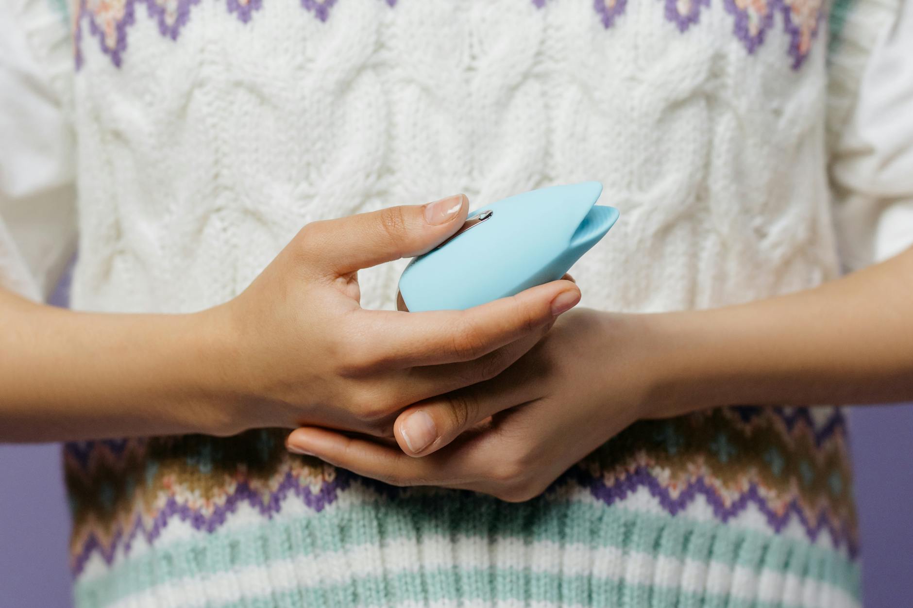 Person holding a blue personal massager, symbolizing gentle reconnection to intimacy after loss