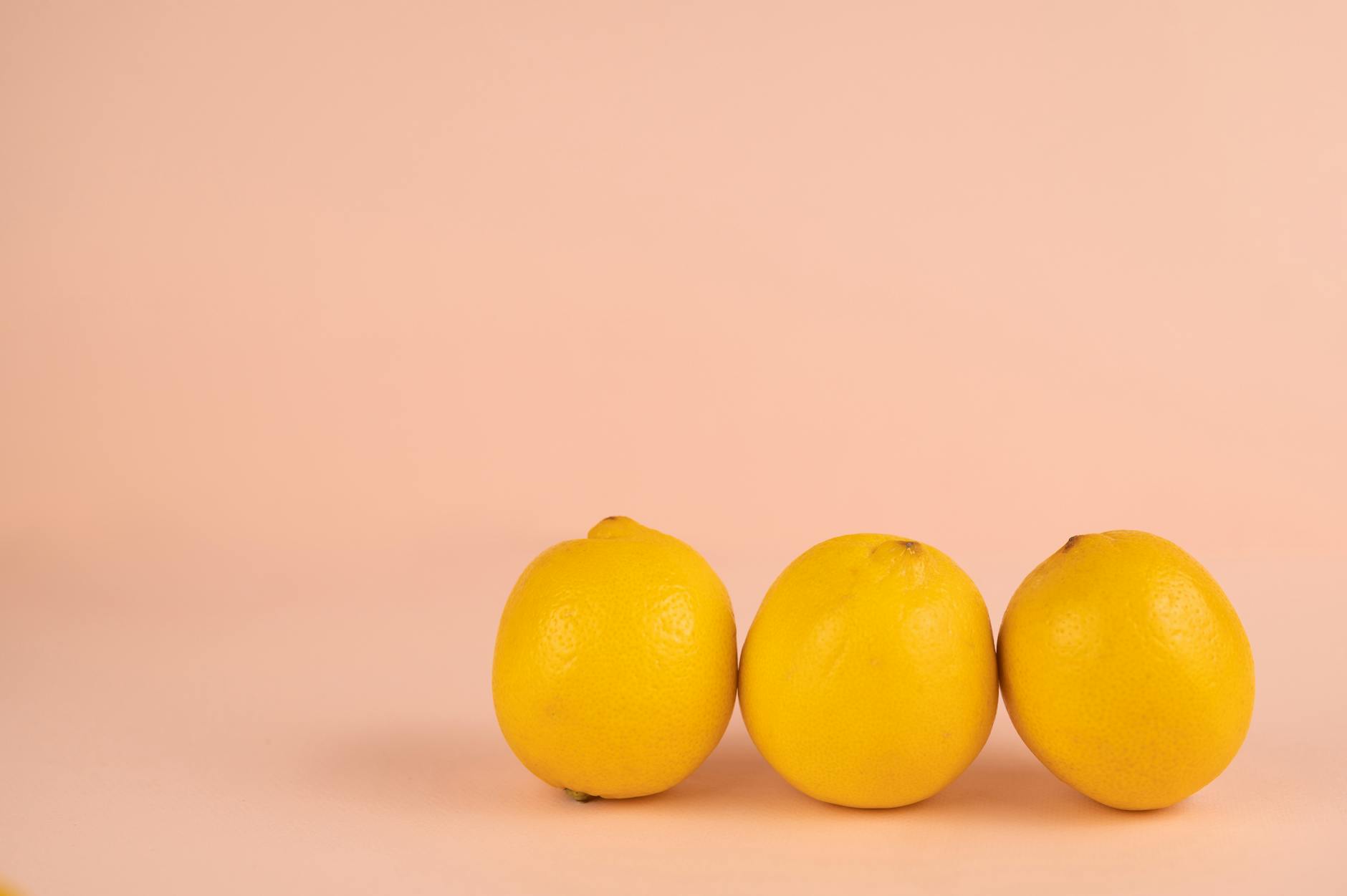 Bright ripe lemons on a soft pastel background symbolizing natural, friction-free pleasure